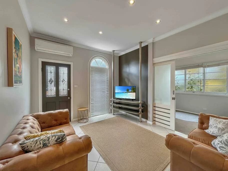 Living room with leather sofas and garden-facing windows