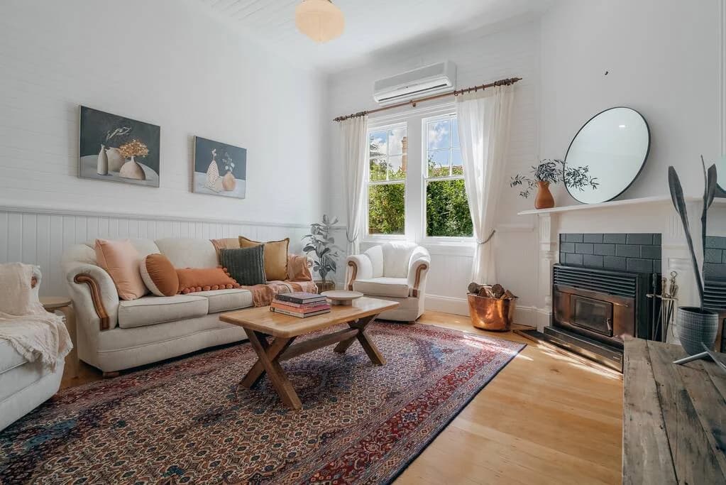 Sunlit living room with fireplace at Quinn’s Cottage in Armidale